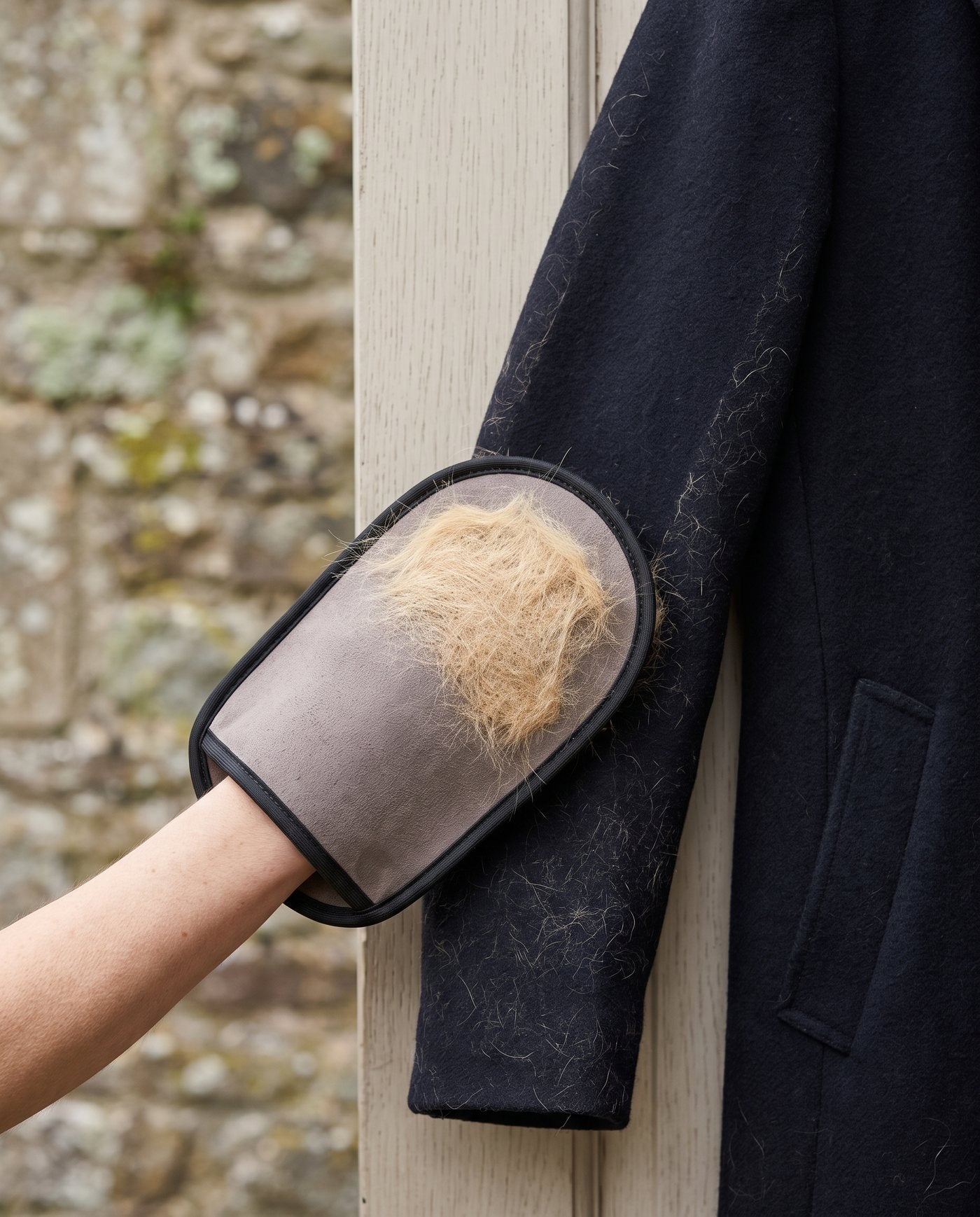 Le gant passé sur la manche d'un manteau en laine sombre