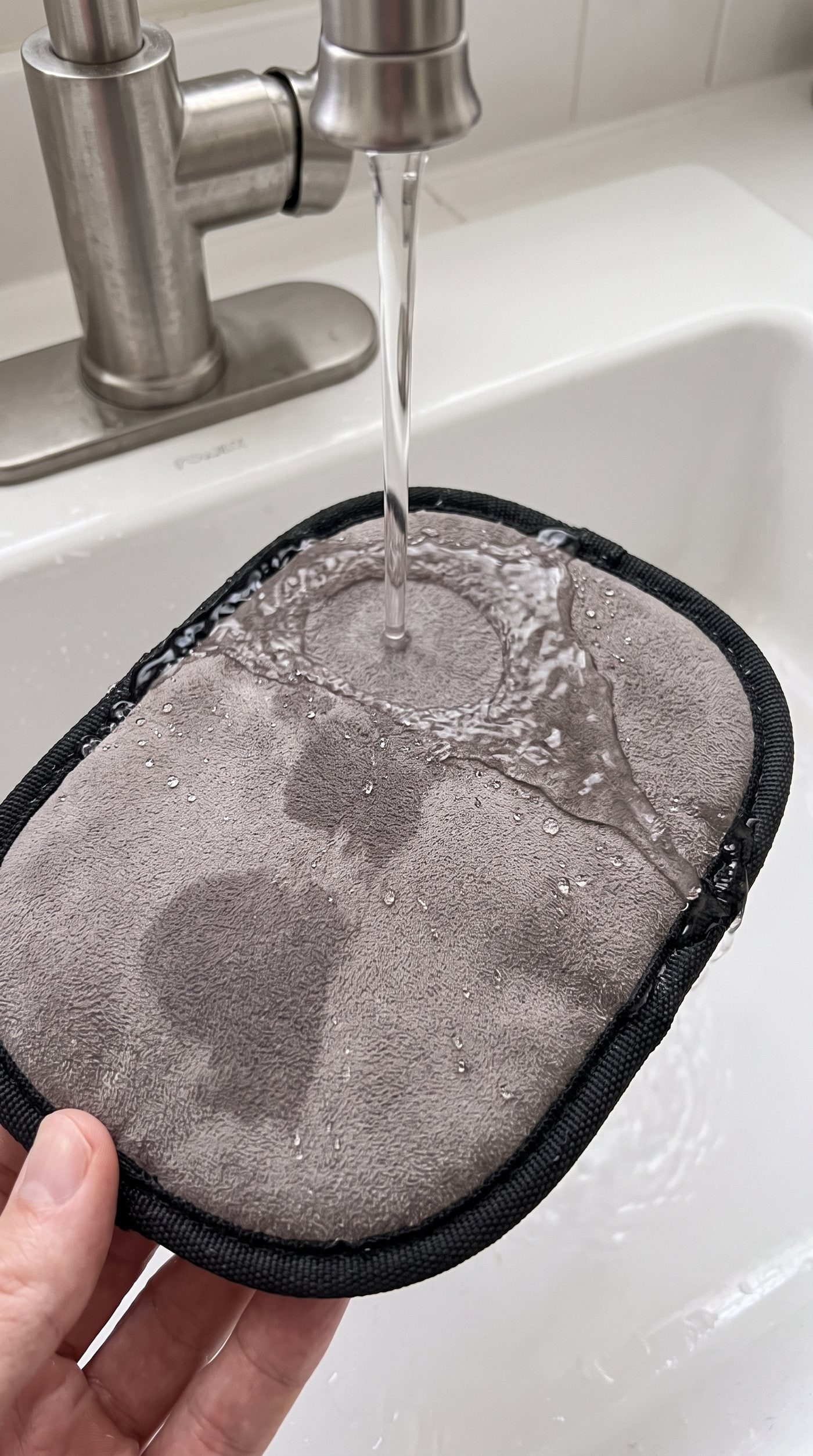 Le gant rincé sous l'eau tiède du robinet