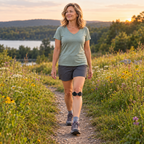 Mature woman walking a trail at sunset wearing a patella strap